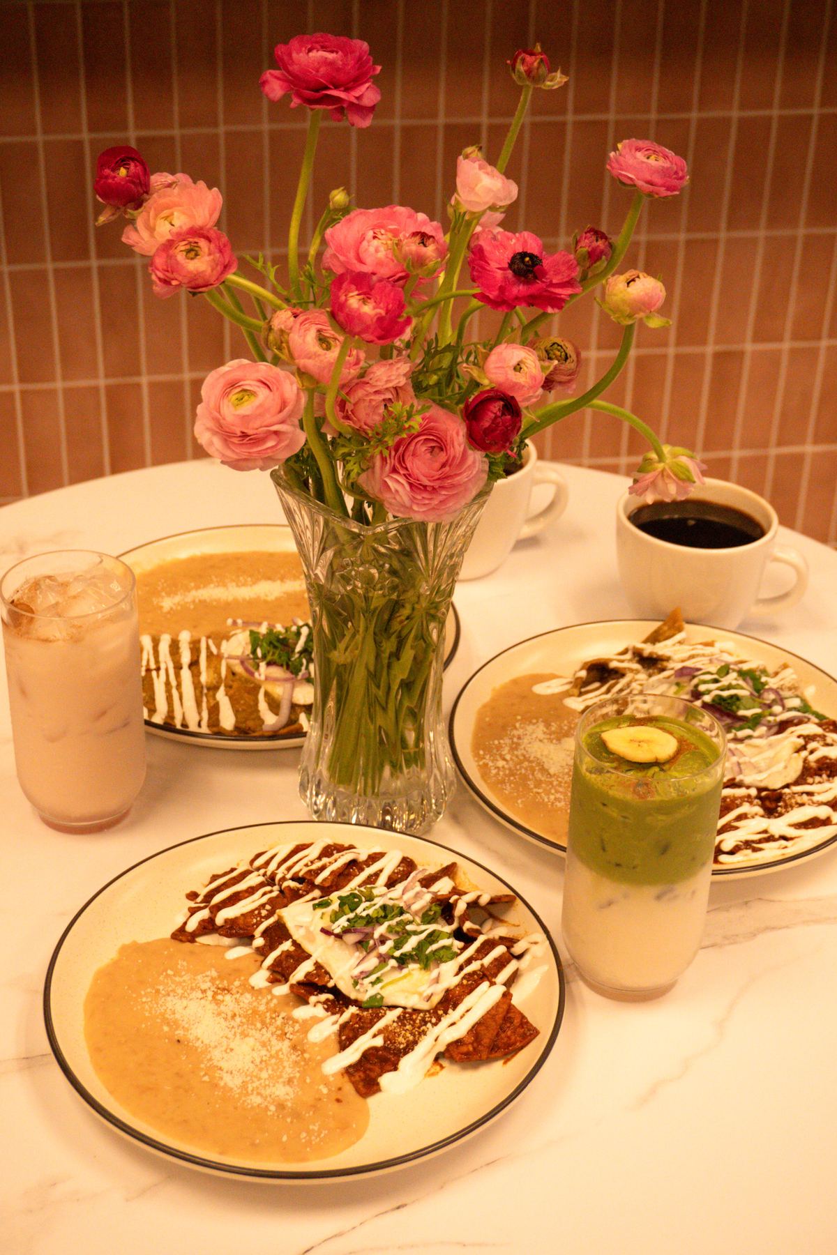 A Casa de Silvia table set with plates, drinks, and fresh flowers
